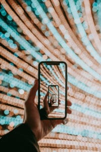 Person holding black smartphone taking photo of white and brown